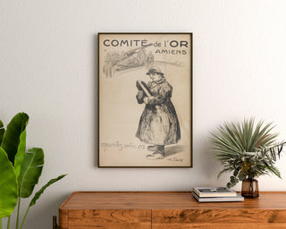 Manifesto storico – Amiens, Comité de l’Or – Abel-Truchet, incorniciato sopra una cassettiera in legno, tra piante.