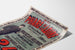 Manifesto pubblicitario vintage Au Phare de la Loire, abbigliamento, presentato su una pagina curva, visto in prospettiva.