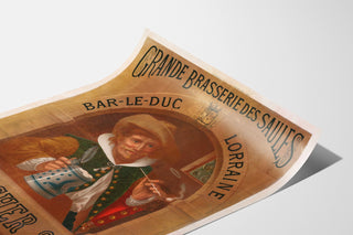 Manifesto pubblicitario vintage Brasserie des Saules, Bar-le-Duc, mostrato su una pagina incurvata, visto in prospettiva.