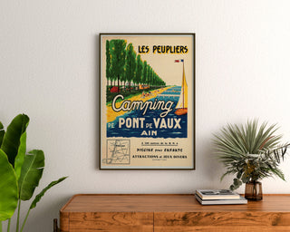 Manifesto turistico vintage – Les Peupliers, campeggio di Pont-de-Vaux, incorniciato sopra una credenza in legno, tra piante.