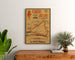 Manifesto vintage Circuit d’Anjou, marcia, incorniciato sopra un comò in legno, tra piante.