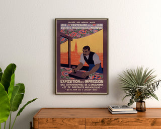 Manifesto vintage Mulhouse, esposizione litografica, incorniciato sopra una cassettiera in legno, tra piante.