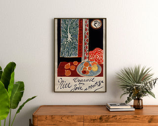 Poster vintage Nice, lavoro e gioia, incorniciato sopra una cassettiera in legno, tra delle piante.