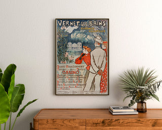 Manifesto vintage Vernet-les-Bains, Canigou, incorniciato sopra una cassettiera in legno, tra piante.